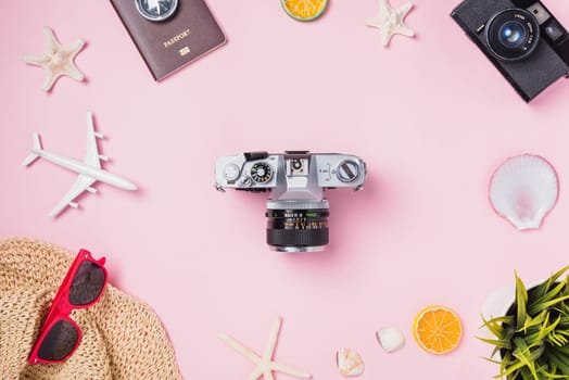 Top view flat lay mockup of retro camera films, airplane, starfish, hat and traveler tropical accessories isolated on pink background with copy space, Business trip, and vacation summer travel concept