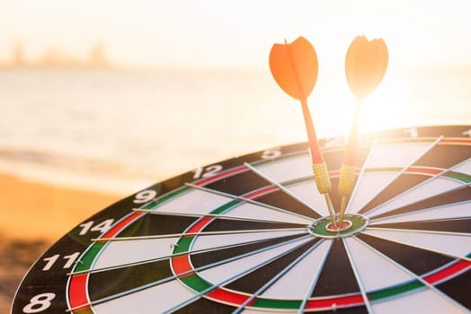Closeup the dart arrow hit center on Bullseye(bull's-eye) of a dartboard is a target of challenge business, strategy marketing target, objective financial and goal a concept