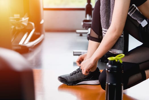 Young woman girl lifestyle sport tied shoelace before training workout exercise cardio at fitness gym