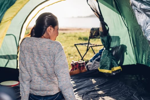 Young woman sitting looking out camping tent on travel outdoor holiday summer
