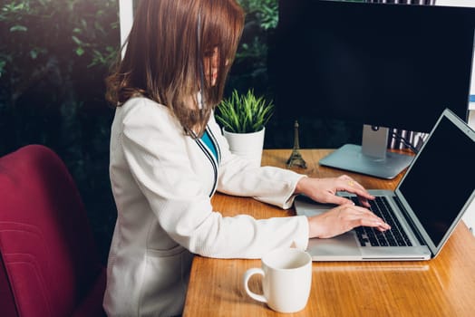 Beautiful business woman sitting working using laptop computer on desk office