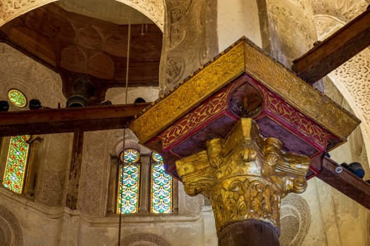 Decorative golden column capital and perforated stucco and stain glass arched windows, at Mamluk era public historical Qalawun complex, Moez Street, Cairo, Egypt