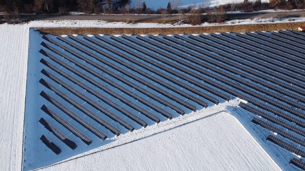 Aerial view with drone of large solar farm in meadow in winter