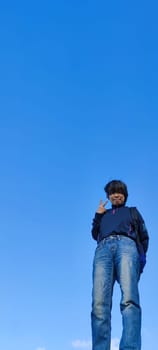 The girl in a jump. Young beautiful woman posing against blue sky bright sunny weather