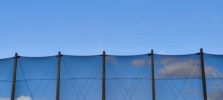 The net against blue sky. Beautiful cirrus clouds. Beautiful cirrus clouds over the sports field