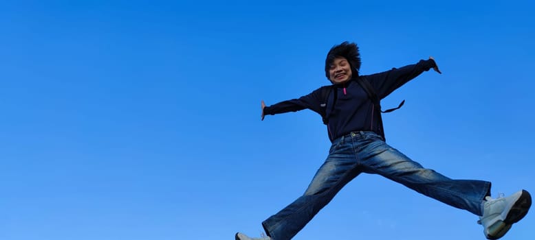 The girl in a jump. Young beautiful woman posing against blue sky bright sunny weather