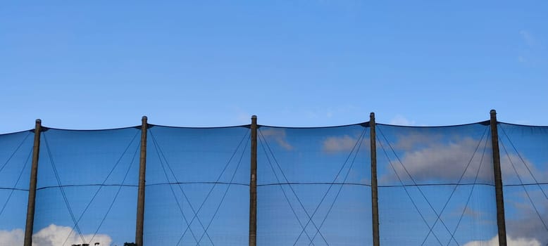 The net against blue sky. Beautiful cirrus clouds. Beautiful cirrus clouds over the sports field