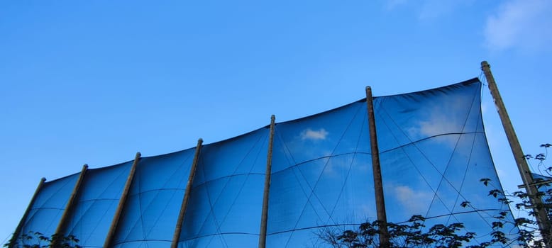 The net against blue sky. Beautiful cirrus clouds. Beautiful cirrus clouds over the sports field