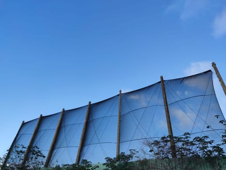 The net against blue sky. Beautiful cirrus clouds. Beautiful cirrus clouds over the sports field