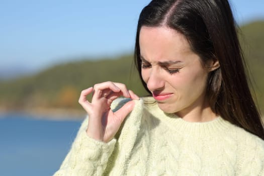 Disgusted woman complaining about bad smell of clothes in the mountain