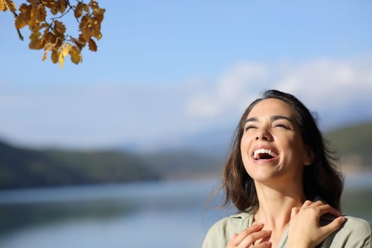 Happy beauty woman laughing outdoors in nature looking above