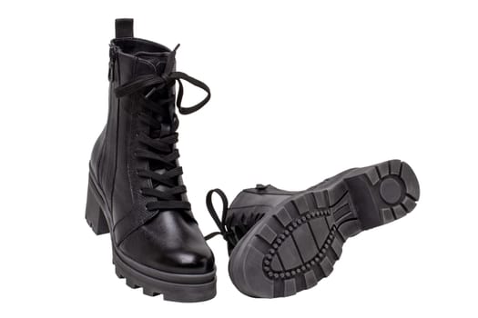Womens boots and shoes. Closeup of female elegant black leather winter boots. Latest trends of winter shoe fashion for girls isolated on white background. Macro.