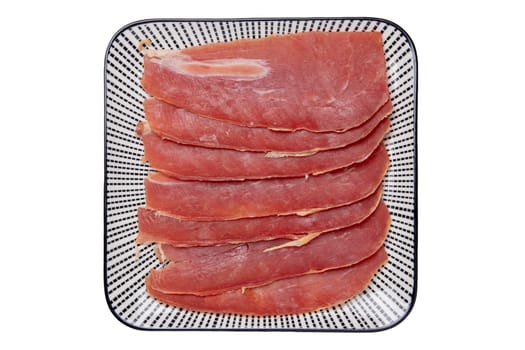 Spanish food. Top view of pieces of sliced dry spanish ham (Jamon Serrano) or italian parma prosciutto crudo on a plate isolated on a white background.