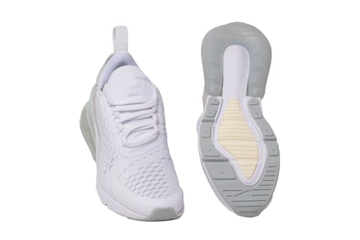 White sneaker isolated. Close-up of a pair white elegant stylish female leather high-heeled sport shoes isolated on a white background. Womens shoe fashion. Modern design footwear for workout. Macro.