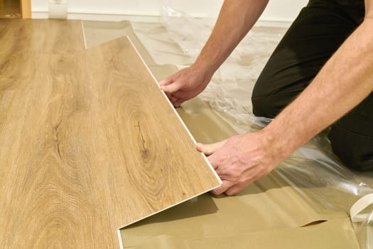 Craftsman renovating an apartment and laying a click vinyl floor covering