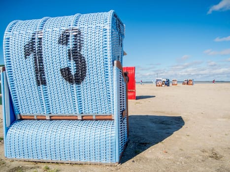 Rear view of a light blue beach chair on the German North Sea coast in summer against a blue sky.