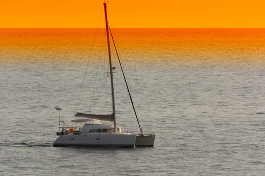 Yacht - catamaran in the tropical sea at sunset. Yachting / luxury sailing theme