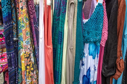 Colorful clothing hangin in front of a shop