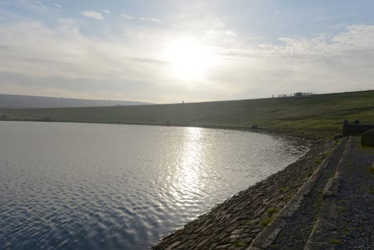 Sheffield, United Kingdom, 7th November, 2020: Looking into the sun over the top dam at redmires reservoirs. Many people enjoy a sunny winters day.