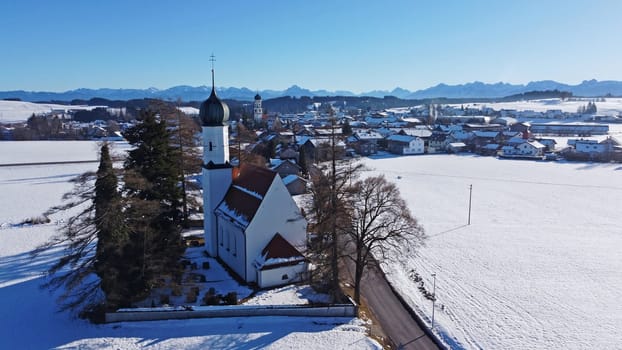 Drone image of the two churches near Leuterschach in Bavaria in front of the Allgaeu Alps in winter