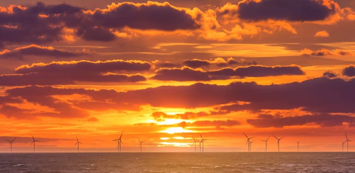 Sunrise at decarbonization industry windmills business for regenerative energies. Clean energy renewables preventing climate change.
