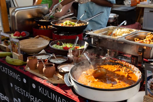 Cheff cooking fusion international cusine on street stall on international street food festival of Odprta kuhna, Open kitchen event, in Ljubljana, Slovenia.