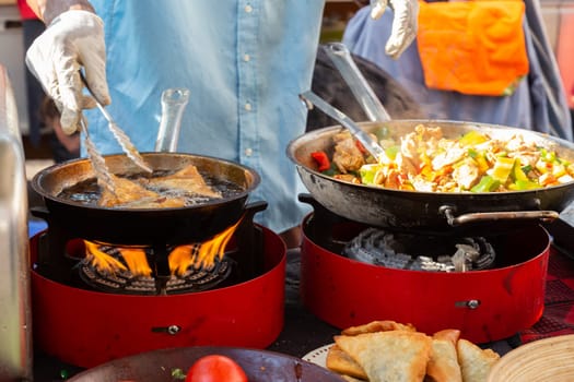 Cheff cooking fusion international cusine on street stall on international street food festival of Odprta kuhna, Open kitchen event, in Ljubljana, Slovenia.