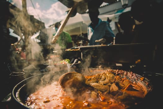 Cheff serving fusion international cusine on street stall on international street food festival of Odprta kuhna, Open kitchen event, in Ljubljana, Slovenia.