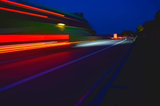 Evening shot of trucks doing transportation and logistics on a highway. Highway traffic - motion blurred truck on a highway-motorway- speedway at dusk.