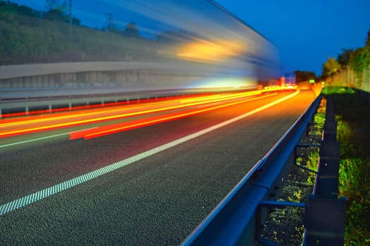Evening shot of trucks doing transportation and logistics on a highway. Highway traffic - motion blurred truck on a highway-motorway- speedway at dusk.