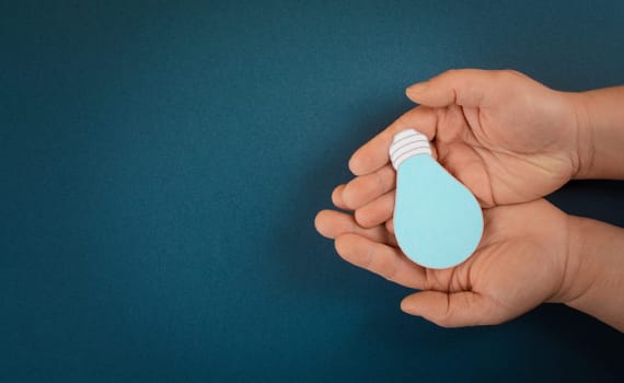 Holding a light bulb in the palm of the hand, creative concept, having new ideas, brainstorming for strategy, start up business
