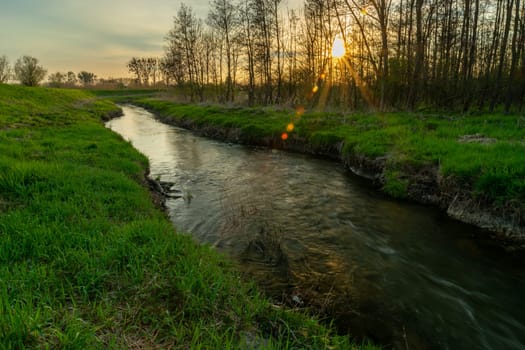 A small river with a green bank and a sunset, Stankow, Lubelskie, Poland