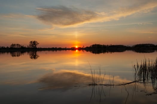 Reflection of cloud in a calm lake at sunset, Stankow, Lubelskie, Poland
