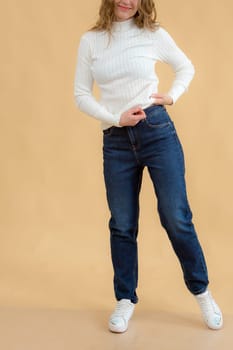 A woman in clothes on the background in the studio, fitting clothes.