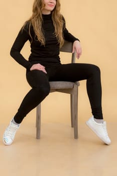 A woman in clothes on the background in the studio, fitting clothes.