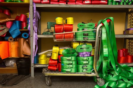 Industrial sewing machine sews a webbing sling. Manufacture of textile slings and tie straps