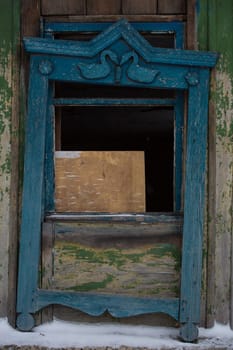 Old wooden shutters on the windows, carved platbands
