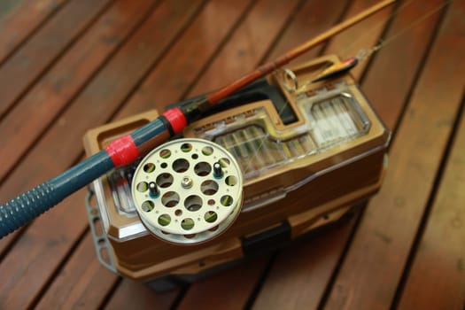 fishing vintage rod with big reel, fishing box for fishing still life