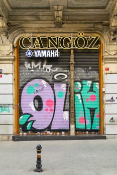 Istanbul, Turkey - April 18, 2017: Closed shop exterior with metal door covered with colorful graffiti near Istiklal Street, Istanbul, Turkey