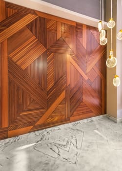 Angled view of hall with wood cladding wall decorated with geometrical patterns, modern glass LED tall chandelier, and white marble floor in modern house