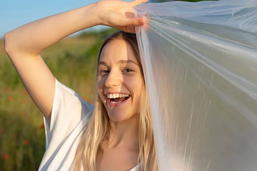 happy young woman with foil in poppy field