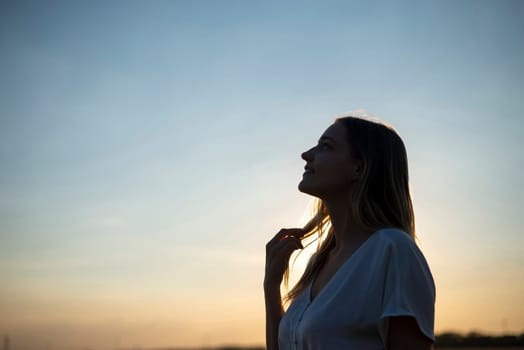 happy young blond woman enjoying sunset