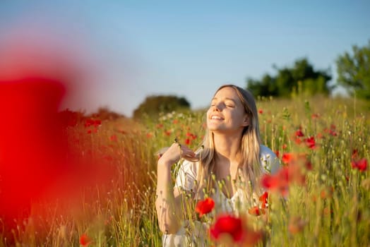 pretty young woman enjoying sun in poppy field