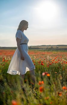sensual young blond woman enjoying evening sun in poppy field