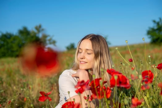 pretty young woman enjoying sun in poppy field