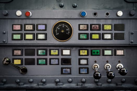Old switches, buttons, and levers on a metal panel as a background for industry.