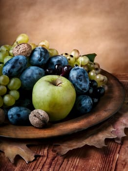 Autumn fruit in wooden plate