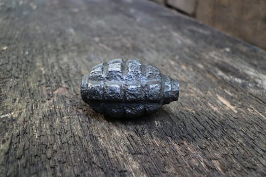 rusty hand grenade on textured wooden surface