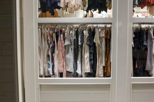 Shop window of clothing and retail store. View of clothes shop with wear hanged on stand