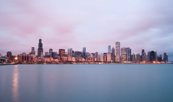 A beautiful pink sunrise lights the long downtown Chicago skyline